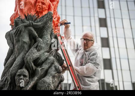 Berlin, Deutschland. 22. Mai 2023. Der Künstler Jens Galschiot malt die „Säule der Schande“ mit roter Farbe. Das Denkmal erinnert an die Opfer der gewaltsamen Unterdrückung der chinesischen Protestbewegung auf dem Tiananmen-Platz in Peking im Juni 1989. Kredit: Hannes P Albert/dpa/Alamy Live News Stockfoto