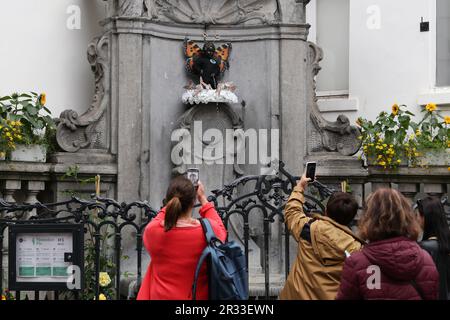 Brüssel, Belgien. 22. Mai 2023. Am 22. Mai 2023 machen Menschen Fotos vom Manneken-Pis in Brüssel, Belgien. Belgiens berühmte Statue Manneken-Pis wurde montags mit einem Schmetterlingskostüm dekoriert, um den Internationalen Tag der biologischen Vielfalt zu feiern. Kredit: Zheng Huansong/Xinhua/Alamy Live News Stockfoto