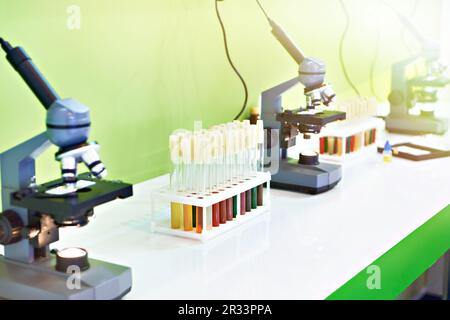 Medizinische Mikroskope und Biofluidproben in Reagenzgläsern Stockfoto