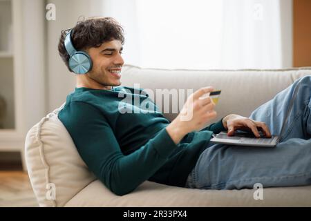 Arabic Man Mit Laptop Und Kreditkarte Zu Hause Einkaufen Stockfoto