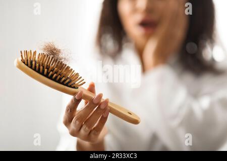 Schockierte Black Lady Holding Bürste Voll Gefallenes Haar Stockfoto