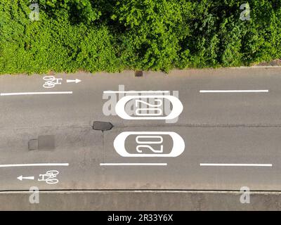 Luftaufnahme der Straßenmarkierungen für eine Geschwindigkeitsbegrenzung von 20 mph und Radspuren. Keine Menschen. Stockfoto