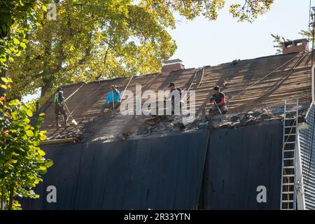 Arbeiter, die das Dach von einem Familienwohnsitz entfernen. Stockfoto