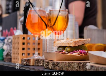 Tassen mit orangefarbenem alkoholischen Cocktail mit Eis auf der Theke - Nahaufnahme Stockfoto