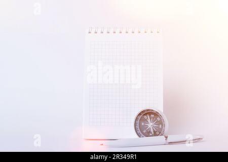 Reisenotizen. Ein sauberes Notizbuch mit Stift zum Schreiben eines Kompasses und einer Karte. Das Konzept des Reisens. Stockfoto