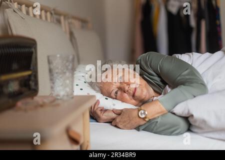 Seniorin schläft allein in ihrem Bett. Stockfoto