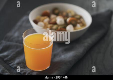 Orangefarbene Limonade aus Glas auf schwarzem Holztisch, flacher Fokus Stockfoto