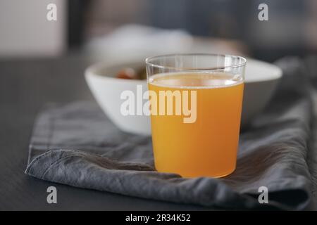 Orangefarbene Limonade aus Glas auf schwarzem Holztisch, flacher Fokus Stockfoto