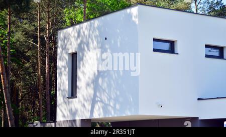 Gehobenes Haus in einem Waldgebiet. Fragment einer Einfamilienhausfassade. Stockfoto