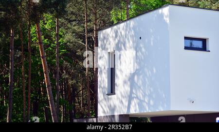 Gehobenes Haus in einem Waldgebiet. Fragment einer Einfamilienhausfassade. Stockfoto