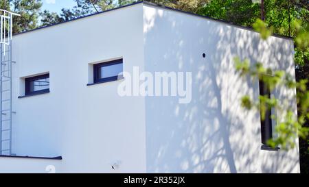 Gehobenes Haus in einem Waldgebiet. Fragment einer Einfamilienhausfassade. Stockfoto