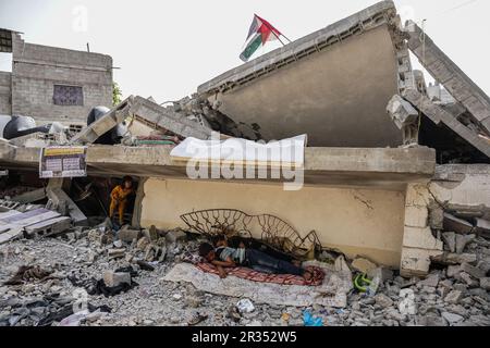 Gaza, Palästina. 22. Mai 2023. (INT) die Palästinenser sitzen auf ihrem Haus, das von den israelischen Besatzungsflugzeugen zerstört wurde. 22. Mai 2023, Gaza, Palästina: Palästinenser aus der Familie Nabhan sitzen auf den Trümmern ihres Hauses, das von den israelischen Besatzungsflugzeugen in Jabalia im nördlichen Gazastreifen zerstört wurde. Mehr als 50 Menschen lebten im Haus, darunter 5 Menschen mit besonderen Bedürfnissen. Kredit: Saher Elghorra/Thenews2 (Foto: Saher Elghorra/Thenews2/Zumapress) (Kredit: © Saher Elghorra/TheNEWS2 via ZUMA Press Wire) NUR REDAKTIONELLE VERWENDUNG! Nicht für den kommerziellen GEBRAUCH! Stockfoto