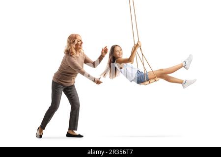 Mutter schubst ein Mädchen auf einer Schaukel, isoliert auf weißem Hintergrund Stockfoto