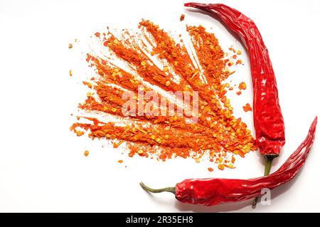 Rote heiße Chili-Paprika und gemahlener Pfeffer auf weißem Hintergrund Stockfoto