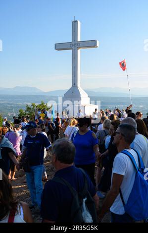 Pilger an einem frühen Morgen rund um das weiße Kreuz auf dem Gipfel des Berges Križevac (der Kreuzberg) in Medjugorje. Stockfoto