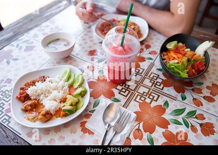 Köstliche thailändische Küche: Gerichte und Menschen in einem lokalen Café. Stockfoto