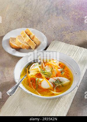 Fischsuppe mit Gemüsestreifen und Seehechtklößchen Stockfoto