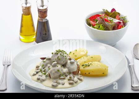 Königsberger Klopse (Fleischbällchen in weißer Sauce mit Kapern) mit gesalzenen Kartoffeln und Salat Stockfoto