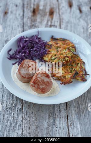 Schweinemedaillons mit einer cremigen Senfsauce, serviert mit einem Kartoffel- und Apfelkuchen und Rotkohl Stockfoto