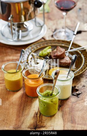 Fleischfondue und verschiedene Saucen Stockfoto