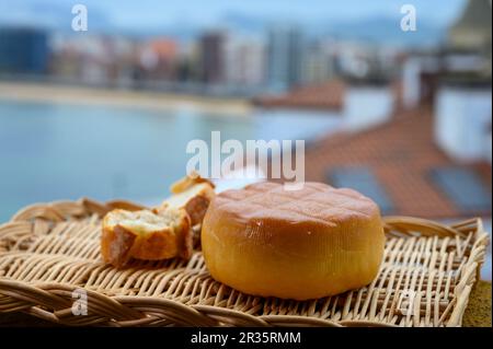 Spanischer hart geräucherter Kuhkäse aus Pria, Asturien, serviert im Freien mit Blick auf den Strand San Lorenzo und die Promenade in Gijon Stockfoto