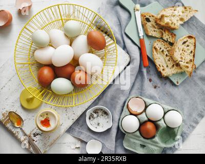 Braune und weiße Eier in einem Korb und in einer Eierschachtel Stockfoto