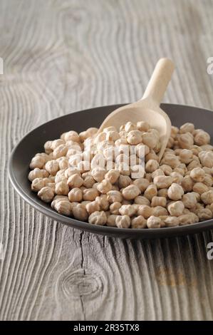 Kichererbsen in einer Schüssel mit einer Holzschaufel Stockfoto