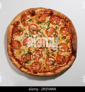 Pizza mit Tomaten und Basilikum (von oben gesehen) Stockfoto