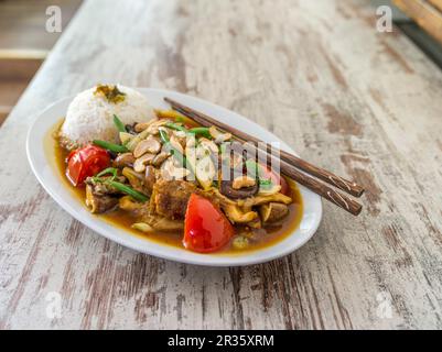 Huhn mit Pilzen, Cashewnüsse, Tomaten, Bohnen und Reis (Asien) Stockfoto