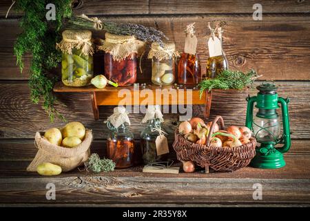 Verschiedene Gemüse- und Pilzkonserven auf einem Holzregal Stockfoto