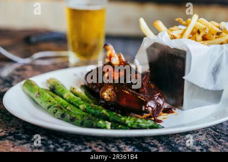 Grillhähnchen mit grünem Spargel und Pommes frites Stockfoto