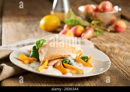 Bachforelle mit weißer Sauce, Aprikosen, Spinat und gewürfelten Kartoffeln Stockfoto