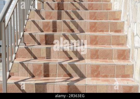 Wunderschöne geflieste Treppen mit Metallgeländern im Freien Stockfoto