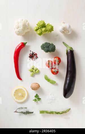 Verschiedene Gemüsesorten, Gewürze und Kräuter auf einer weißen Oberfläche Stockfoto