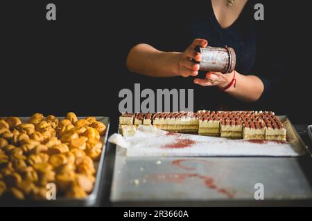 Tiramisù Sahnescheiben, die mit Kakao abgewischt werden Stockfoto