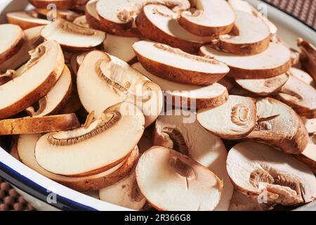 Geschnittene, frische braune Pilze in einer Emaille-Schüssel Stockfoto