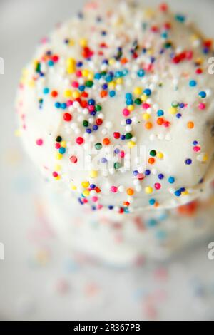 Butterkekse mit weißer Glasur und bunten Zuckerstreuern Stockfoto