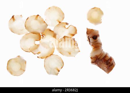 Galangal in Scheiben auf einer weißen Oberfläche Stockfoto