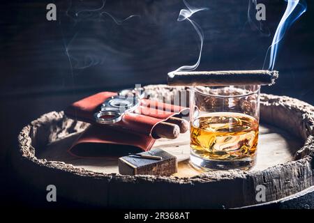 Eine rauchende Zigarre über einem Glas Whiskey Stockfoto