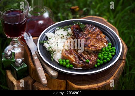 Gegrilltes Schweinekragen-Steak mit Reis und Erbsen Stockfoto