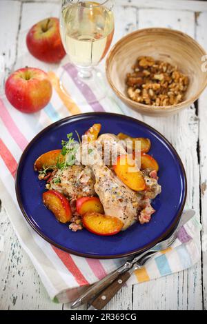 Hähnchenschenkel in Apfelwein mit Äpfeln und Walnüssen Stockfoto