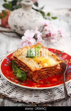 Stück Lasagne auf einem weißen Teller; Weißer Hintergrund Stockfoto