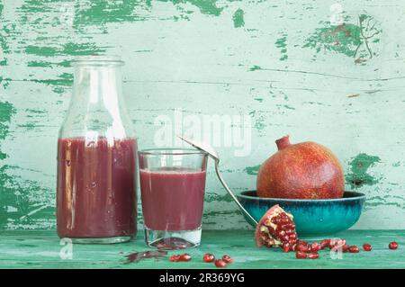 Eine Anordnung von Granatäpfeln und Granatapfelsaft in einer Flasche und einem Glas Stockfoto