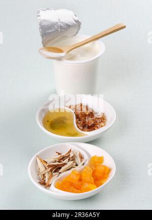 Joghurt, Honig, Steinzucker, Kokosnuss und kandierte Früchte Stockfoto