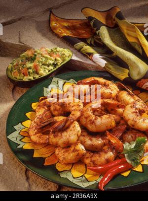 Scharfe Garnelen mit Guacamole, serviert in Avocado-Schale Stockfoto