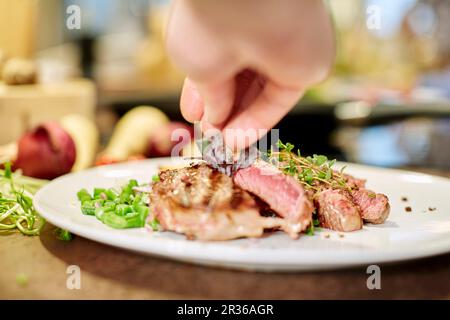 Gegrilltes Rindersteak wird garniert Stockfoto