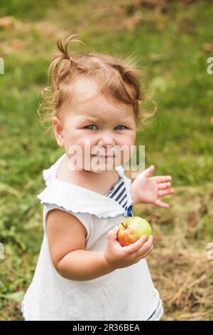 Babymädchen unter dem Apfelbaum Stockfoto