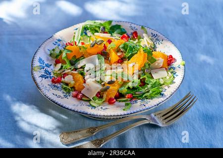 Rucolasalat mit Orangen, Granatapfelsamen, Parmesankäse und Kürbiskernen Stockfoto