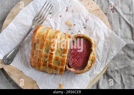 Beef Wellington, in Scheiben geschnitten, auf ein Stück Papier (von oben gesehen) Stockfoto