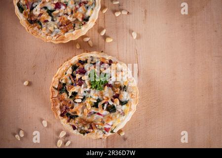 Blätterteig Quiche mit Mangold, Speck, Ziegenkäse und Pinienkernen Stockfoto